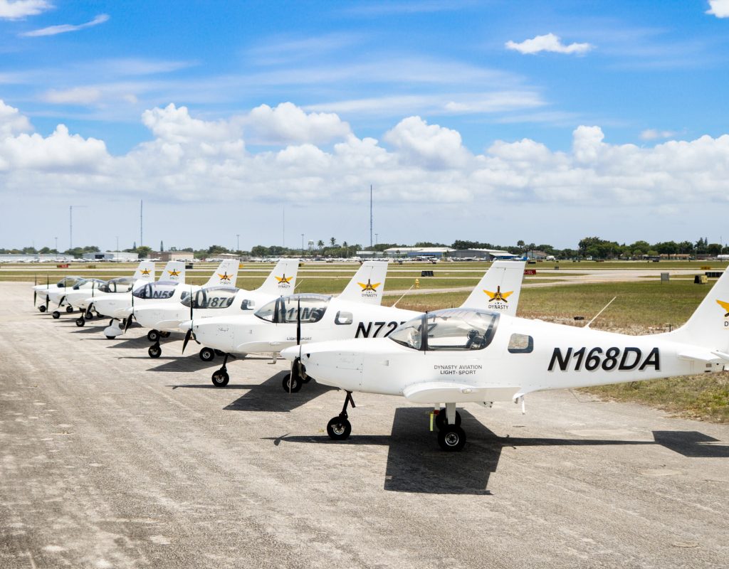 instructor guiding student through cockpit controls at Dynasty Aviation Inc airplane